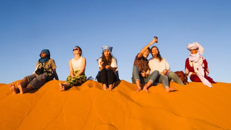 Tourists enjoying Agadir activities in the desert dunes at sunset