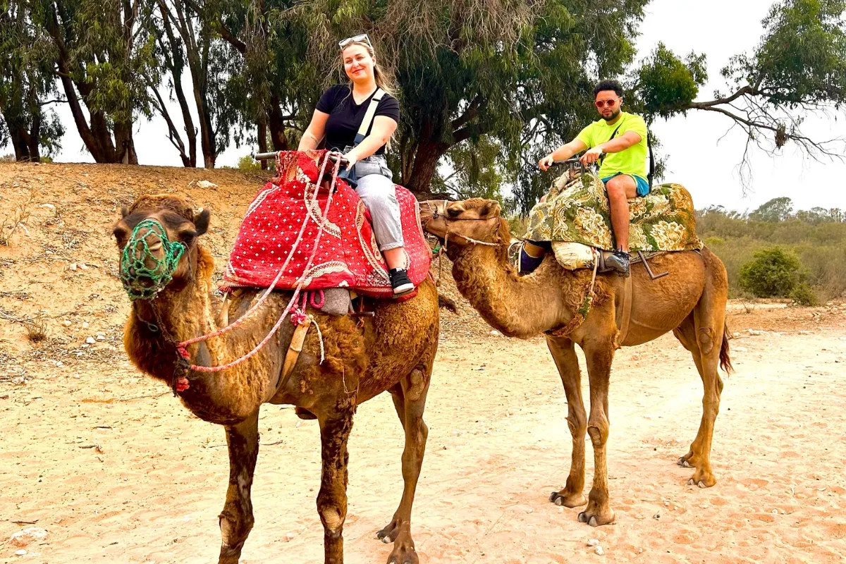 Couple enjoying a colorful agadir camel ride through nature.
