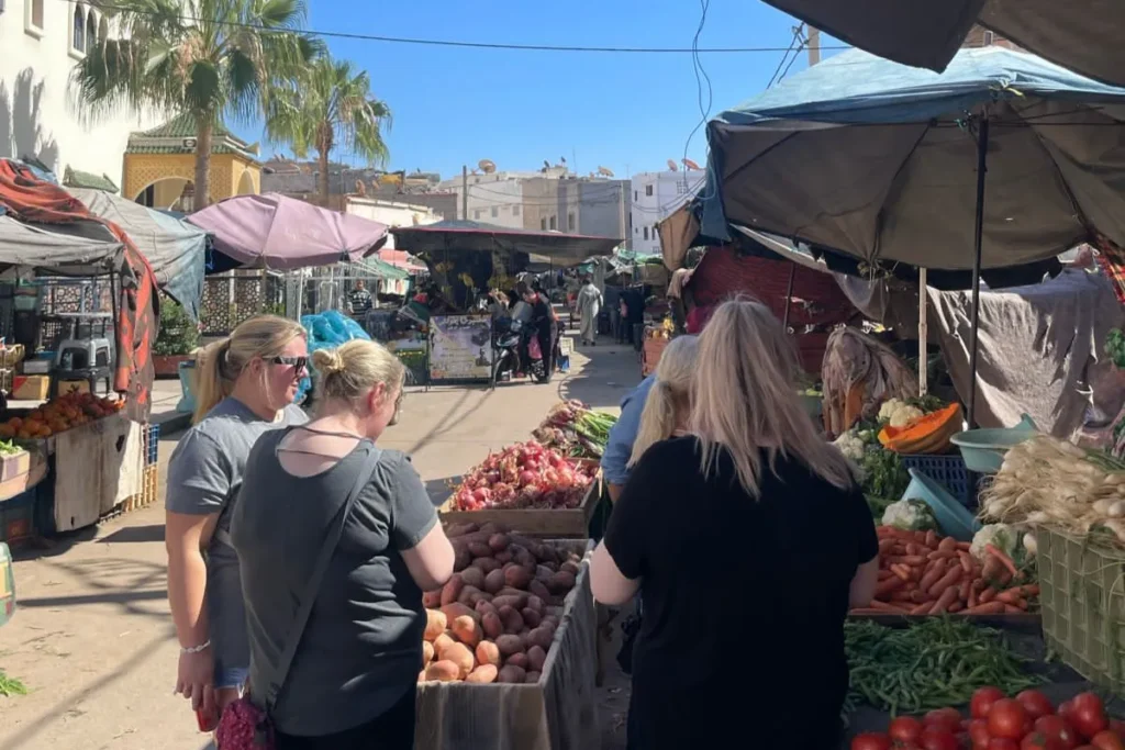 Participants selecting fresh vegetables at local market for Agadir Cooking Class