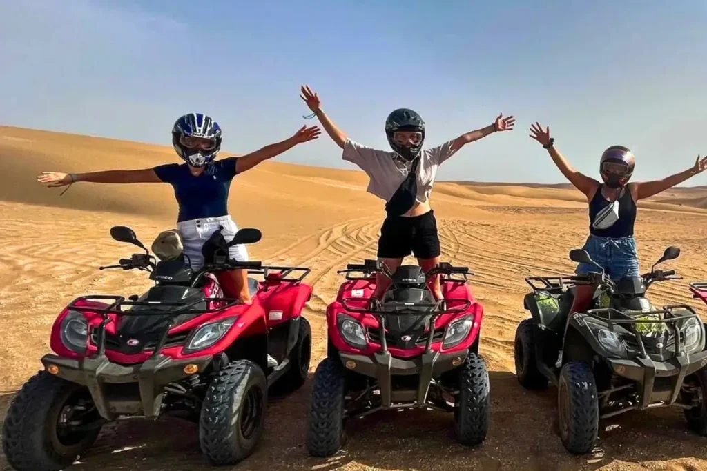 Three women posing on quad bikes during a Quad Agadir tri
