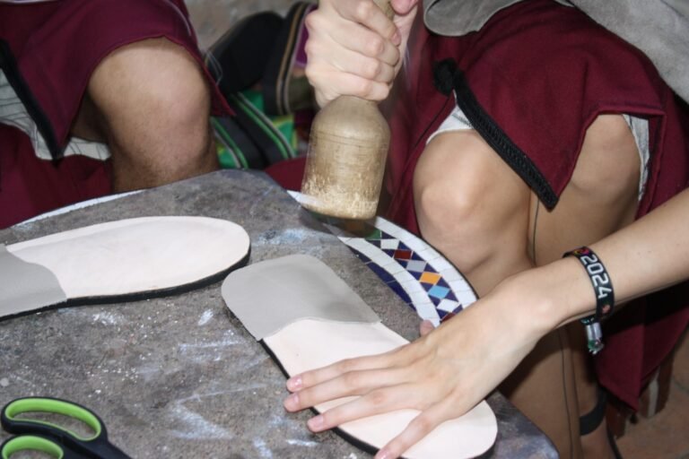 Shaping a leather sole with a wooden mallet during a babouche workshop in Agadir