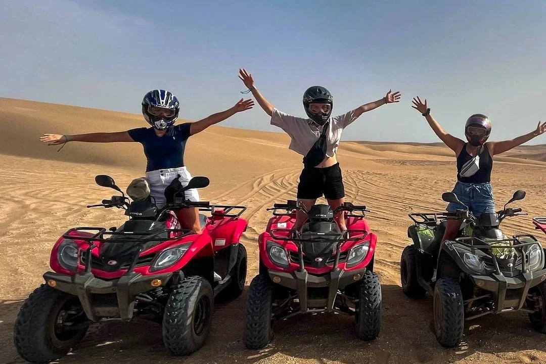 Quad bikers celebrating on sand dunes, one of the top Agadir activities