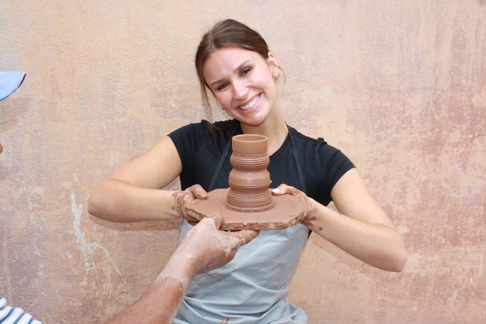 Visitor holding a handmade clay vase during an Agadir pottery workshop
