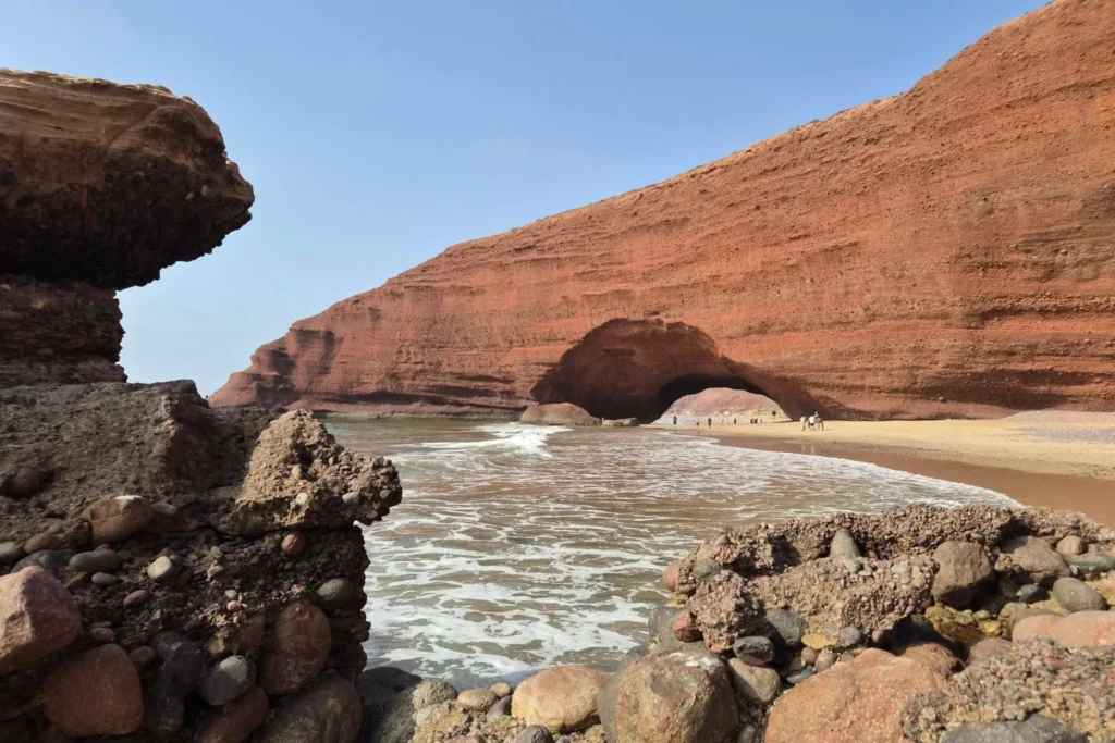Natural red rock arch over the beach at Legzira, Morocco