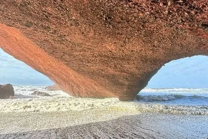 View through the natural rock arch at Legzira looking out to the ocean