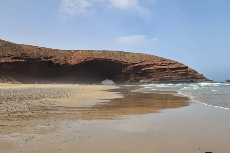 Wide view of the red rock arch and beach at Legzira