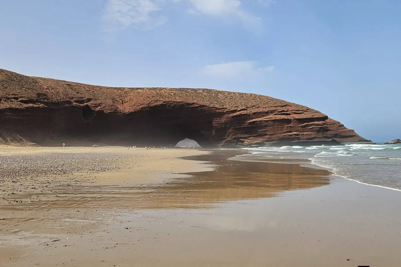 Wide view of the red rock arch and beach at Legzira