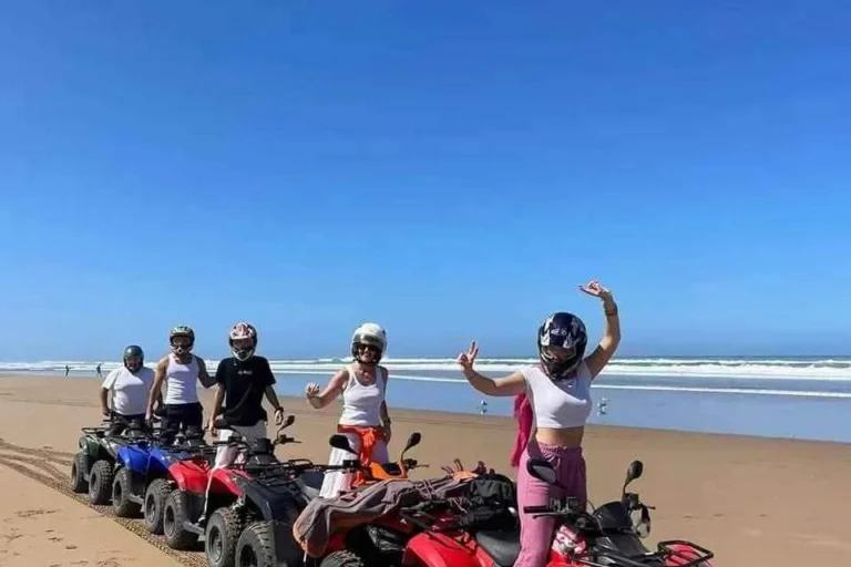 Friends posing next to quad bikes on the beach after a ride near Agadir