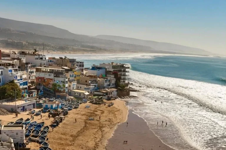 Aerial view of Taghazout village with fishing boats, surfers and the beach